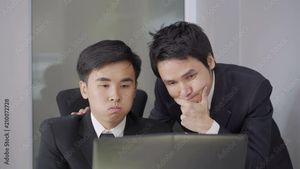serious stressed two business man using laptop computer to working project