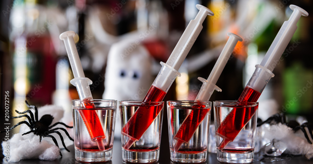 creepy halloween party cocktails with syringes of grenadine syrup as blood, shot drinks at party - obrazy, fototapety, plakaty 