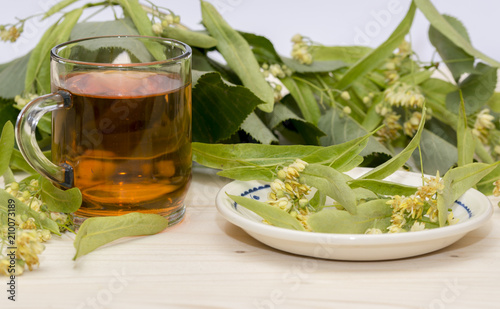 Linden tea in a glass cup blossoms and linden leaves