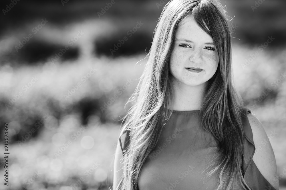 Close-up of a beautiful young girl with long hair looking into the camera lens on black and white photography Close-up of a beautiful young girl with long hair looking into the camera lens on black and white photography