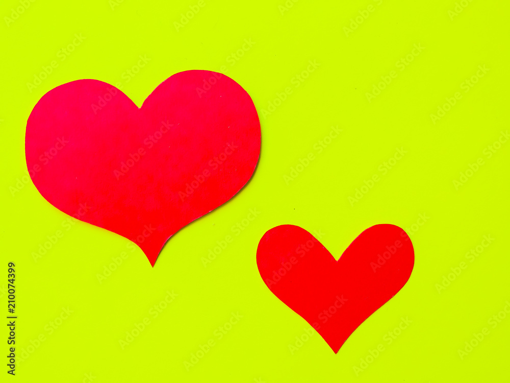 Red paper hearts on a yellow-green paper background