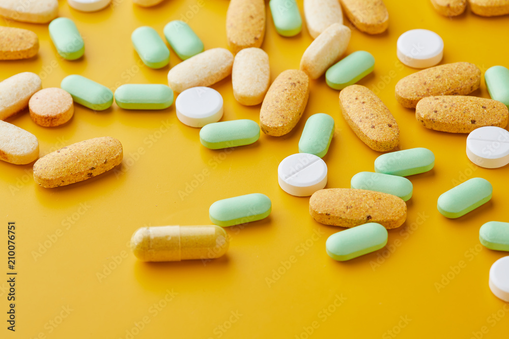 Pills and capsules. Pile of white capsules and redish tablets used as medication or supplements. Pills and capsules. Pile of white capsules and redish tablets used as medication or supplements.