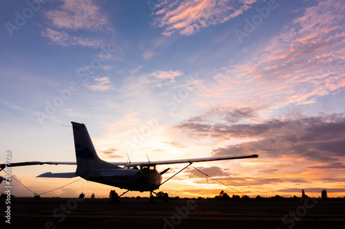 beautiful landscape image with silhouette of old wing airplane at sunset