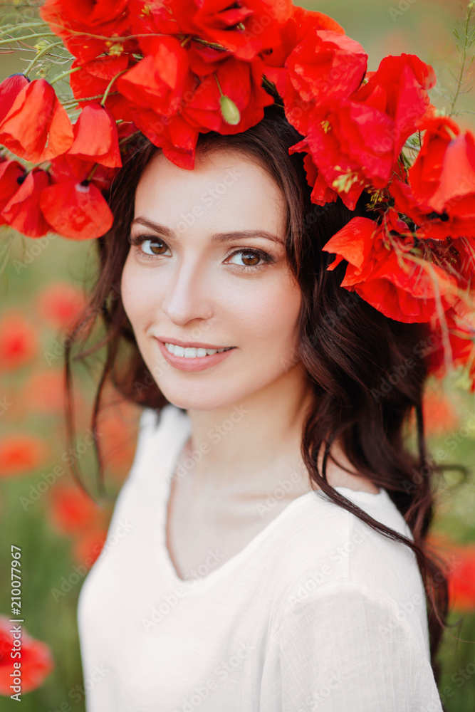 Beautiful girl in red poppy field