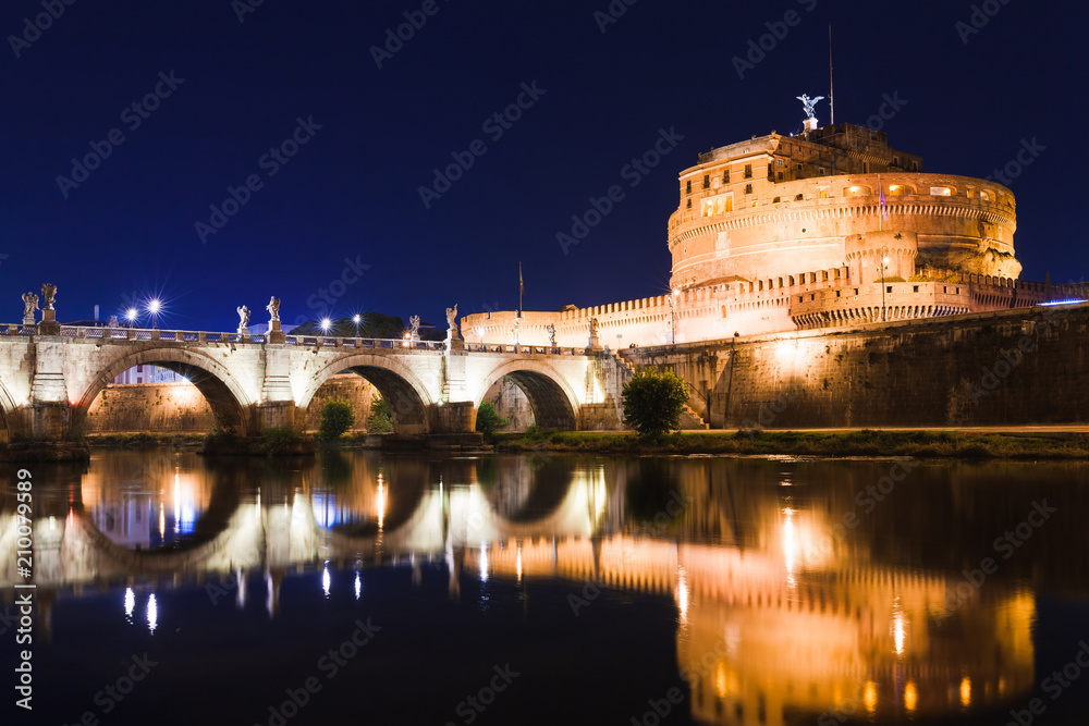 Cityscape romantic night view of Roma. Panorama with Saint Peter's basilica and Saint Angelo castle and bridge. Famous tourist destination with Tiber. Travel illuminated landscape in Italy, Europe.