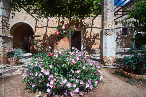 Fototapeta Naklejka Na Ścianę i Meble -  Blooming flowers in the courtyard of the historic Orthodox monastery Moni Arcadia on the island of Crete.