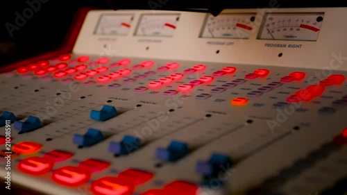 Panning shot on a radio station sound board close up with glowing buttons in 4k. photo