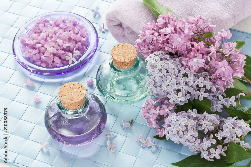 Aromatherapy essential oil / Aromatherapy essential oil in glass bottle, sea salt, towel and lilac flower for SPA