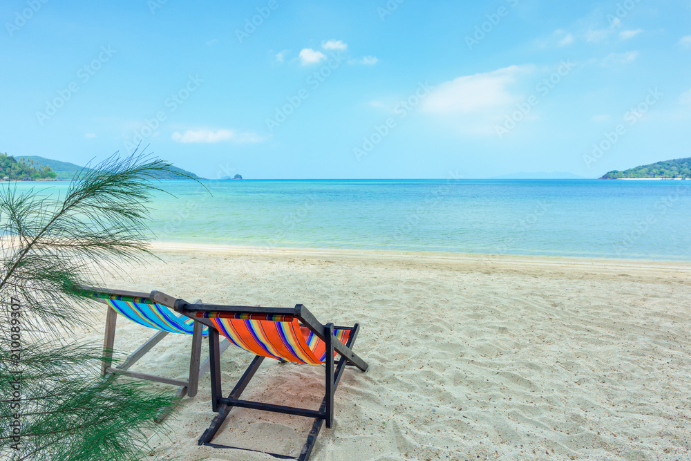 Beach chairs on the white sand beach and tropical sea in Thailand.
