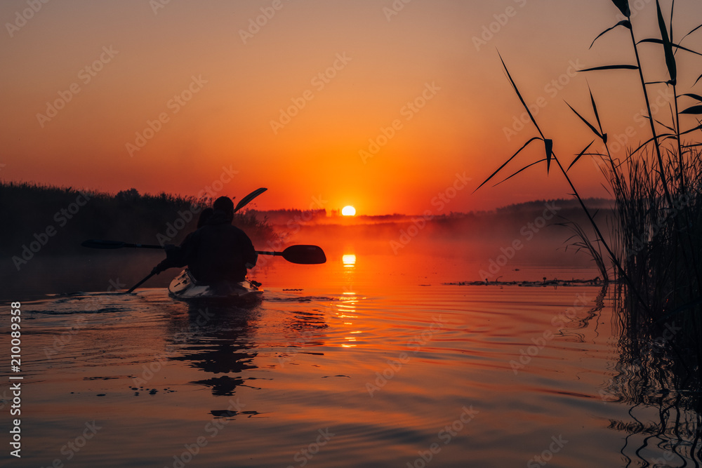 People kayaking down the river at sunrise People kayaking down the river at sunrise