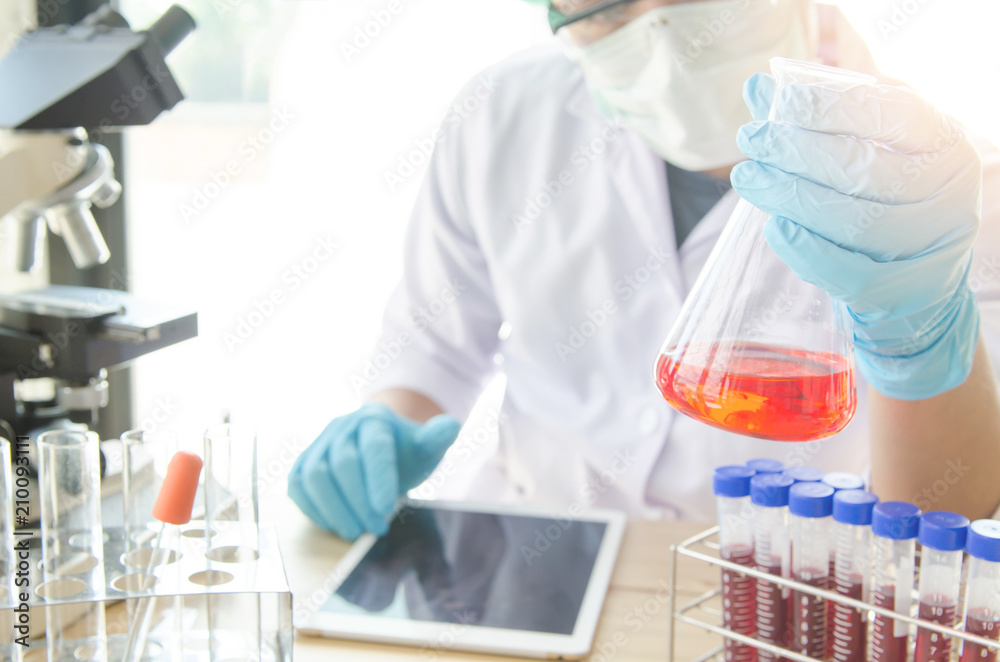 Young scientist looking through a microscope in a laboratory. Young scientist doing some research.