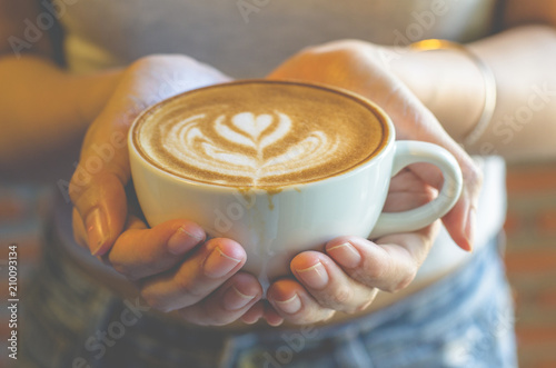 woman holding a cup of coffee in the morning, selective focus.