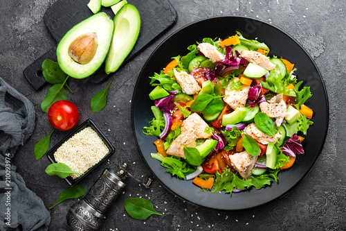 Salad with fish. Fresh vegetable salad with salmon fish fillet. Fish salad with salmon fillet and fresh vegetables on plate