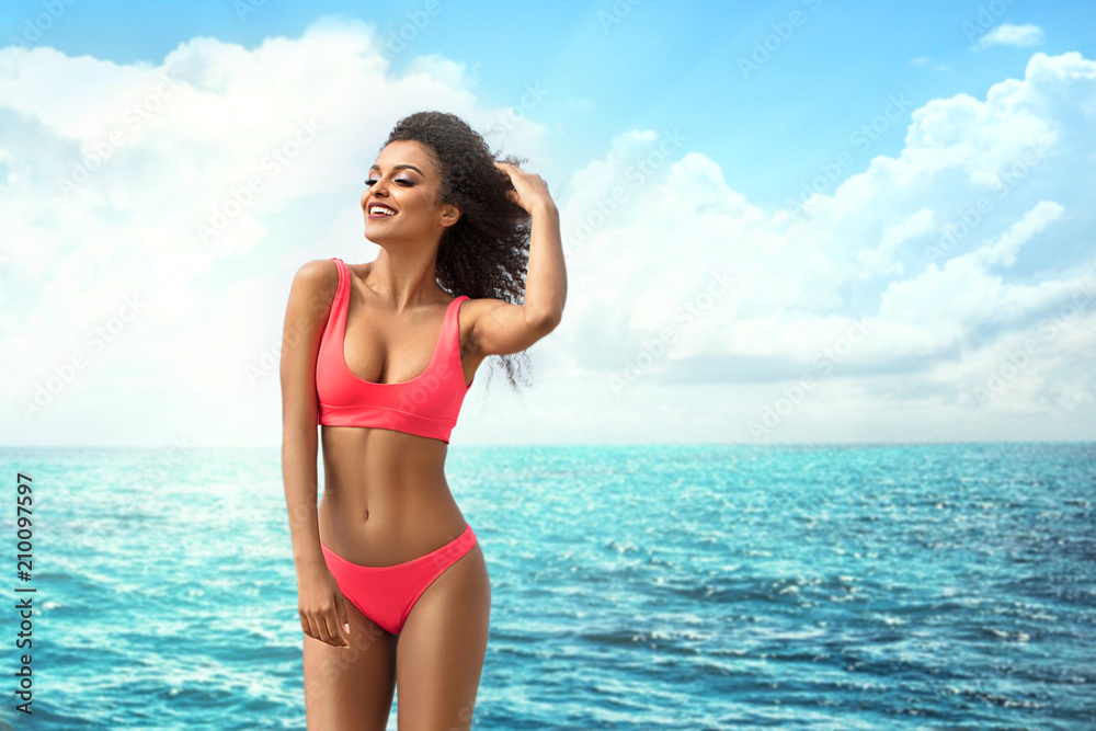 Attractive smiling girl posing on the beach. - obrazy, fototapety, plakaty 