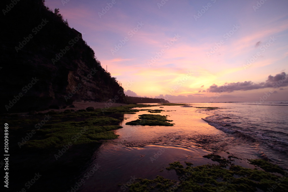 Magenta purple sunset colors reflected in tide pools
