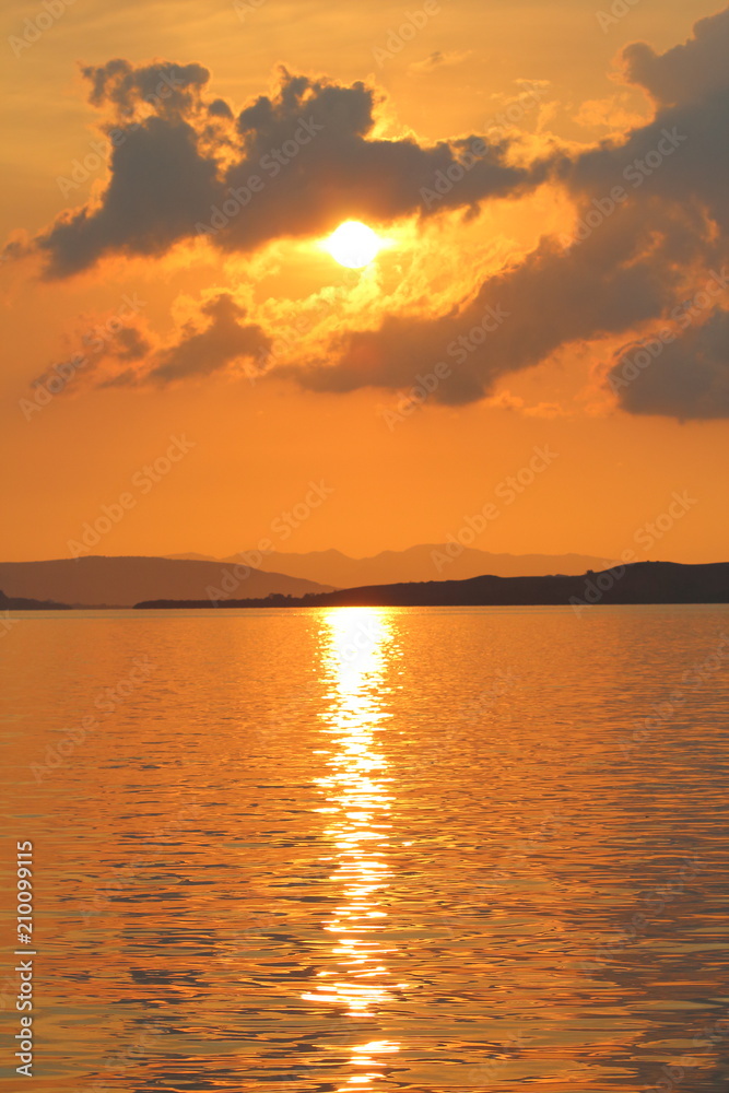 Portrait orange sunset with ocean, islands, and clouds