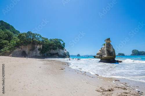 Cathedral Cove in Coromandel Peninsula on the North Island of New Zealand. People can seen exploring around it. photo