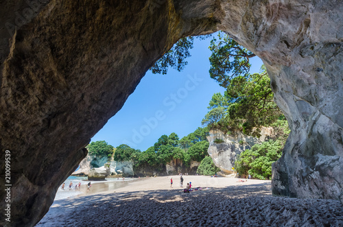 Cathedral Cove in Coromandel Peninsula on the North Island of New Zealand. People can seen exploring around it.