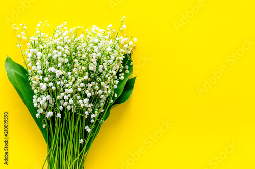 Fototapeta Naklejka Na Ścianę i Meble -  Small and fragrant spring flowers. Bouqet of lily of the valley flowers on yellow background top view copy space