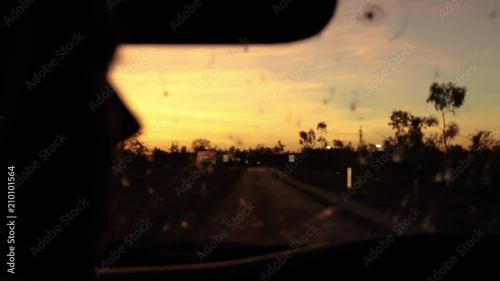A medium shot of a window and a road on a dark dawn sky