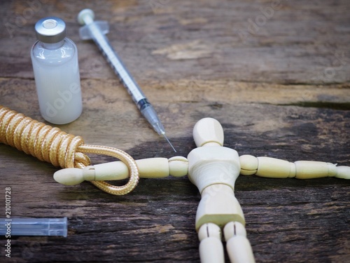 Injection needle with rope and wooden puppet. Meaning Punishment by Injection for Death Penalty photo