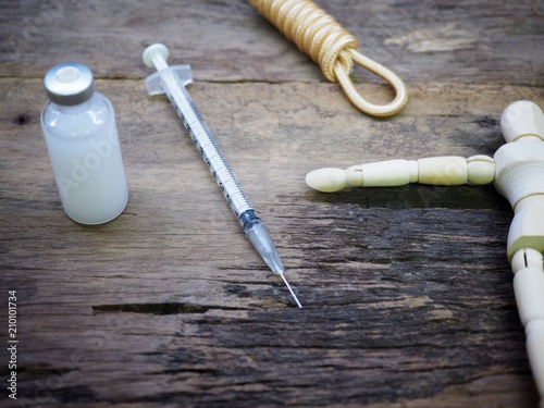 Injection needle with rope and wooden puppet. Meaning Punishment by Injection for Death Penalty photo