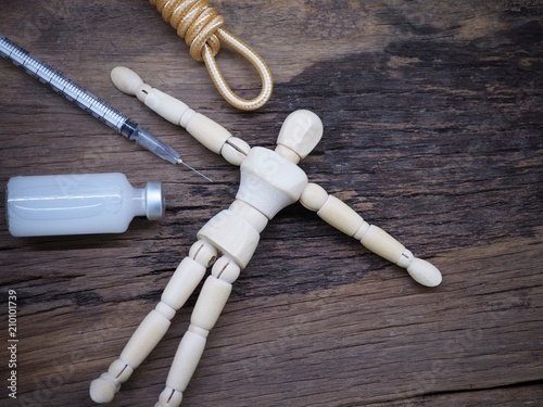 Injection needle with rope and wooden puppet. Meaning Punishment by Injection for Death Penalty photo