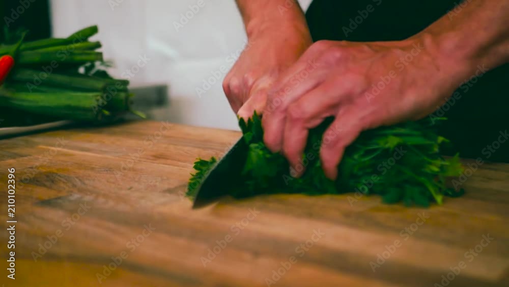 Slow motion close up of parsley being copped up for a salad or cooking Slow motion close up of parsley being copped up for a salad or cooking
