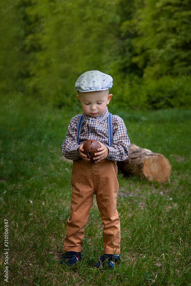 Little boy with a large chocolate egg in the nature