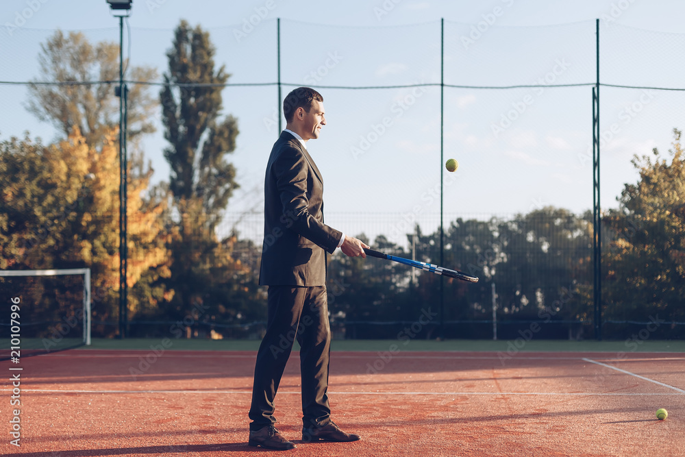 Businessman hitting the ball with racket