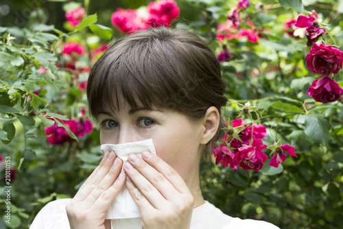 Young girl covers his nose with paper handkerchief, spring and summer allergie