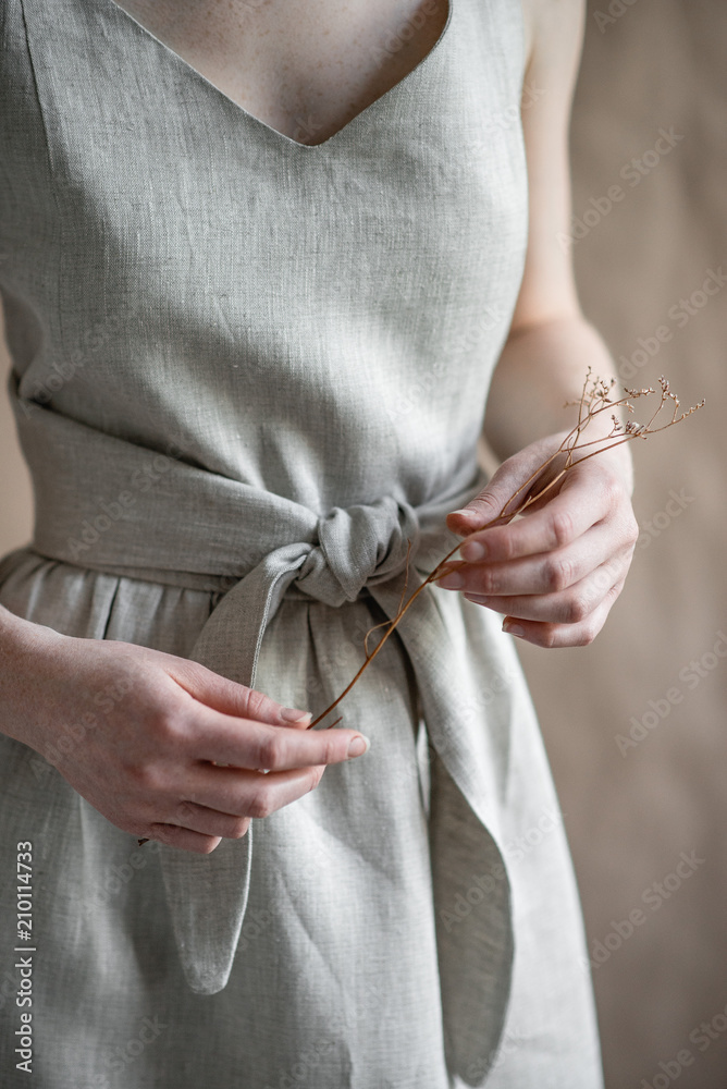 Girl in the dress holds dry branch