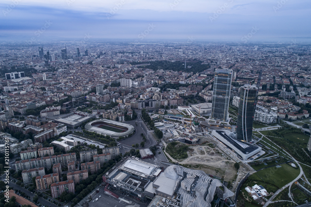 Aerial view of Milan (Italy) at dawn. On the right the new two skyscrapers of the CityLife district and the building site of the third tower.