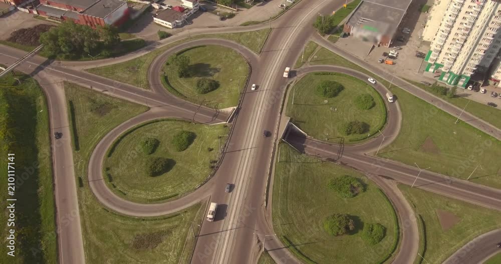 Top view round road junction in the smoll city in summer. active city traffic cars. Aerial flight. 4K Top view round road junction in the smoll city in summer. active city traffic cars. Aerial flight. 4K