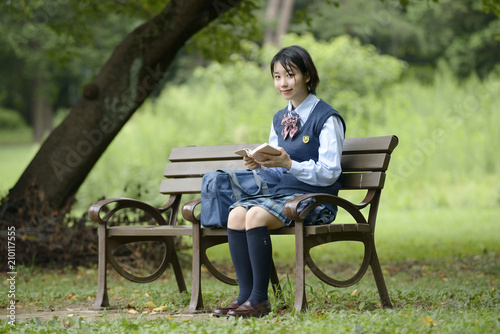 ベンチで本を読む女子高生