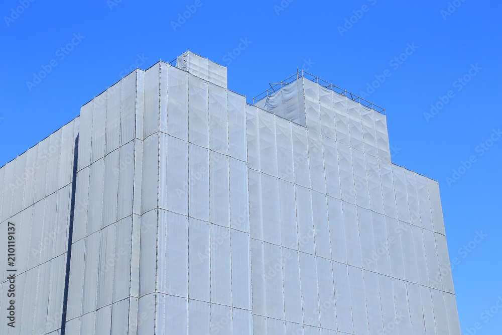 Renovating building with gray safety nets Renovating building with gray safety nets