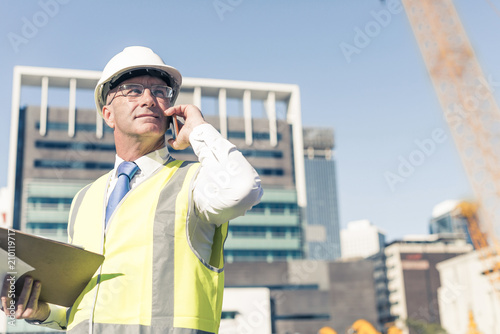 Man architector outdoor at construction area having mobile conve