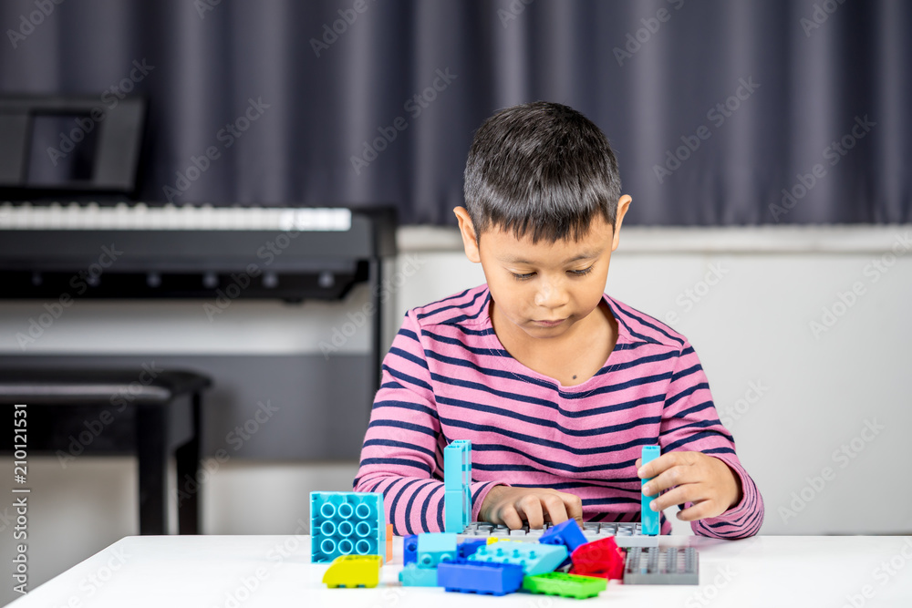 Young Asian boy playing and building with colorful plastic bricks learning and development Young Asian boy playing and building with colorful plastic bricks learning and development
