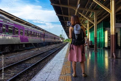 Female Tourist with backpack bag standing on platform at train station - travel concept by train.  © Kitsada