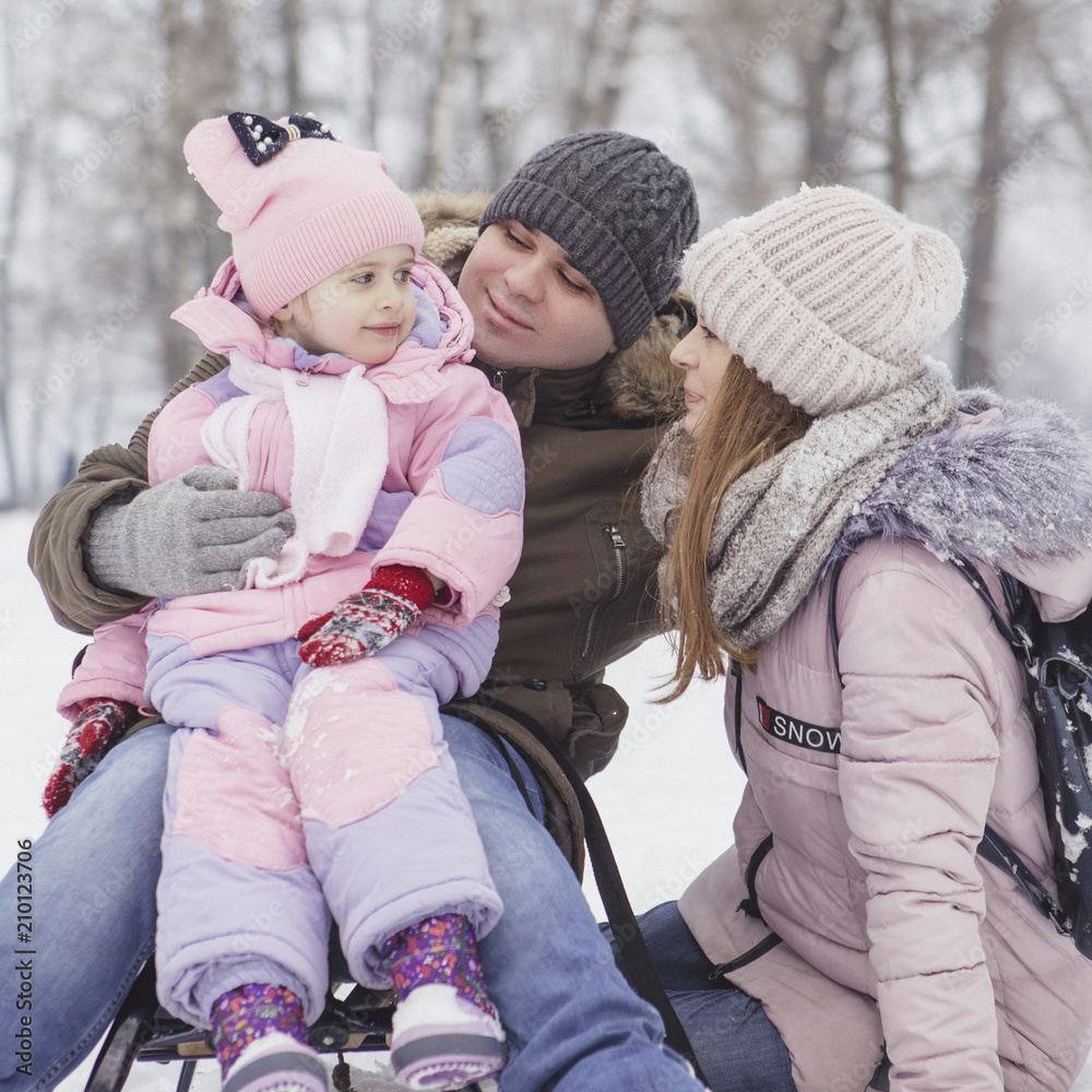 Obraz premium Happy loving caucasian family of mother father and daughter play, having fun in winter snowy park