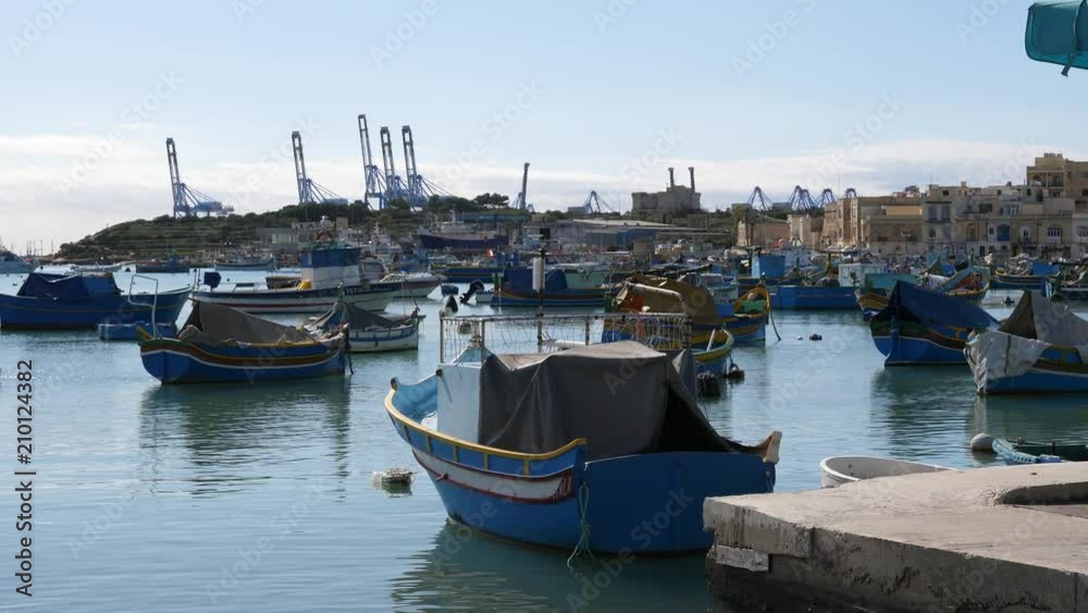Color boats by coastline in beautiful fishing village of Marsaxlokk in Malta