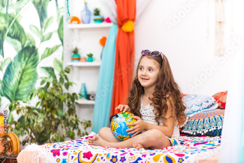 Little Girl with a globe in the arabic interior © Inna Vlasova