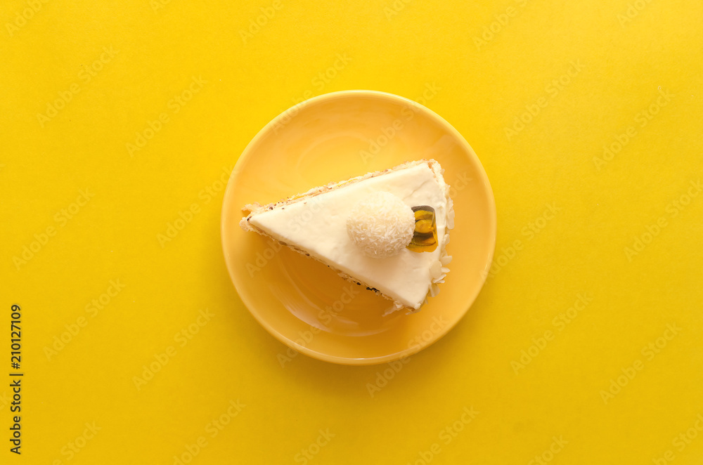 Sponge cake with hazelnut, cheese-coconut cream on natural cream and marmalade layer of passion fruit isolated on yellow background.