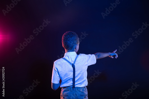 World of technologies. Dark-haired afro-american boy pressing imaginary buttons and wearing a shirt and trousers © zinkevych