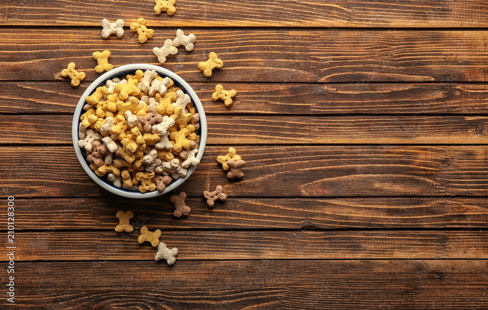 Bowl with pet food on wooden background