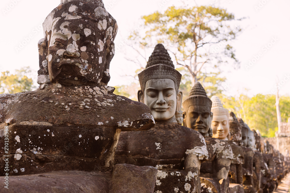 Fototapeta premium Faces at the entrance of Bayon Temple, Angkor Wat, Cambodia.Ancient statues of Buddhas with a soft focus in the temple of Angkor Wat.