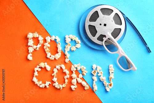 Composition with words POP CORN and film reel on color background