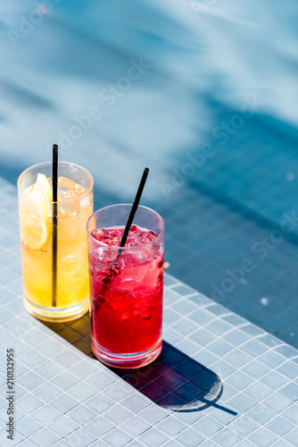 close-up shot of glasses of delicious fruit cocktails on poolside