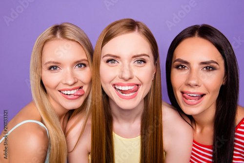 Foto Head shot portrait of fancy funny girls gesturing v-signs looking at camera isolated on bright violet background