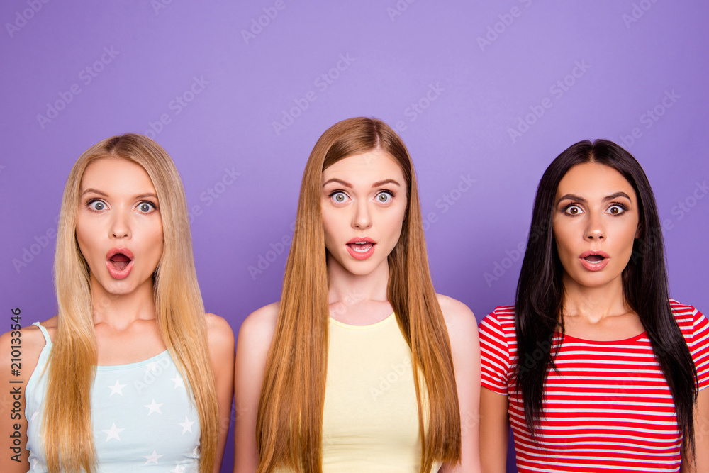 WTF! Portrait of shocked astonished trio with wide open mouth eyes and long hair looking at camera isolated on violet background WTF! Portrait of shocked astonished trio with wide open mouth eyes and long hair looking at camera isolated on violet background